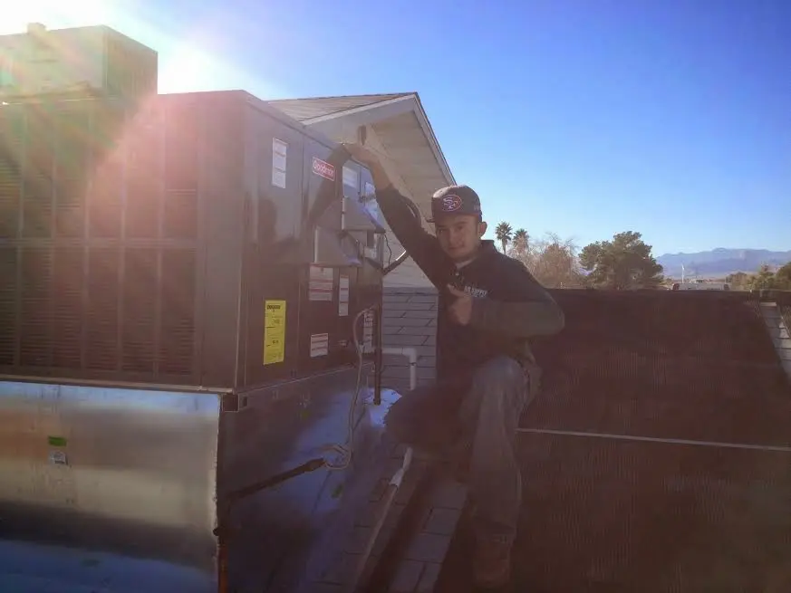 HVAC technician performing HVAC Inspection on a rooftop unit in Maryland City